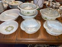 Glass bakeware set on wood table showing Green Daisy, Suburbia Meadow, and Brown Daisy patterns