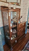 Full front view showing curved glass display section and buffet base with drawers and cupboard
