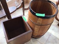 Wooden barrel next to wooden box on floor, showing size and condition