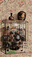 Front view of glass cabinet with miniatures and two vases on top, showing general lot contents