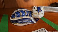Side and front view of blue and gold painted bone china fox figurine paperweight
