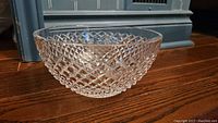 Diamond cut Waterford crystal serving bowl shown from side angle on wood floor.