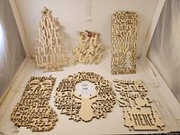 Six wooden Christmas-themed wall décor signs displayed together: a Christmas tree, OH WHAT FUN! sign, rectangular word sign, wreath, stocking, and Santa stop here sign.