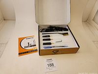 Full foam cutter kit inside box showing components arranged in foam cutout and instruction manual on left