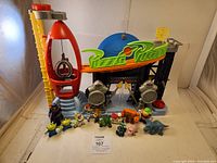Full view of Imaginext Pizza Planet playset with all included figurines in front of it