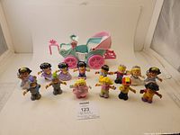 Full lot of 14 Little People figures arranged in front of the carriage on a white background.