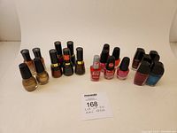 Overview photo of 20 nail polish bottles laid out in rows showing mixed brands and colors.