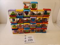 Front view of 26 Peek-a-Boo sensory blocks stacked in columns showing variety of letters and objects inside