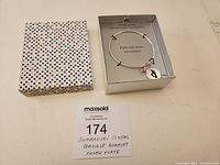 Box with bangle bracelet and paper tag.