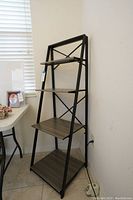 Full view of the 4-tier collapsible shelf showing the black metal frame and composite wood shelves