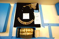 Top view showing the beaded necklace with embellished centerpiece and two gold-tone rhinestone bangle bracelets in original blue boxes