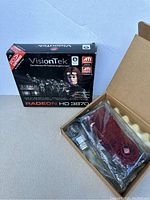 VisionTek RADEON HD 3870 graphics card in original box with card in anti-static bag inside an open box, includes accessories.