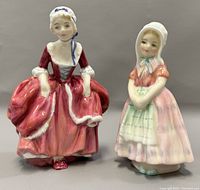 Front view of both figurines showing detailed painting, Tootles in red dress and Goody Two Shoes in bonnet with pink dress.