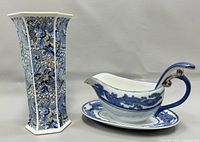 Tall hexagonal ceramic vase with intricate blue floral designs on white background.