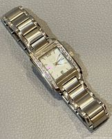 Full watch laid flat on surface showing entire watch and bracelet.