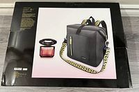 Box packaging showing image of perfume bottle and matching bag with Greek key strap pattern.