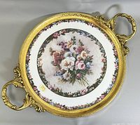 Top view of porcelain dish showing detailed floral bouquet center with green and pink floral border and ornate 22K gold rim and metal handles.