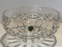 Front view of thick Waterford cut crystal serving bowl showing geometric and leaf cut patterns and original sticker label on side.