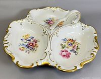 Top-front angle photo of the white porcelain dish with three floral decorated sections and gold trimming.