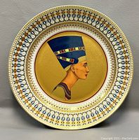 Front photo of the round decorative plate showing full design of Queen Nefertiti's profile and detailed border patterns.