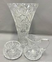 Front view of 9.5" tall pinwheel cut crystal vase with matching creamer and sugar bowl