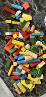 Image showing many assorted wooden blocks in different shapes and painted colors on a carpeted floor.
