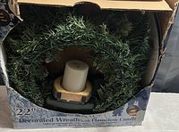 Front view of the 22-inch decorated wreath with flameless candle in original box showing condition and partial product details.