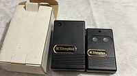 Photo showing the Dimplex remote control transmitter and plug-in receiver alongside the original white box.