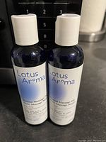 Image showing two bottles of Lotus Aroma Neutral Massage Oil with white caps and blue labels.