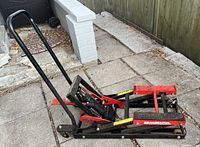 Side angle showing full metal frame with handle and lifting pedal on floor surface.