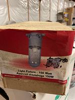 Photo of the original packaging box with label showing image of the 150 watt light fixture and product details.
