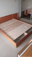 Overall view of queen platform bed frame with headboard and both attached side tables