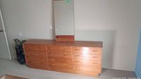 Full view of dresser with unattached mirror leaning on top