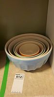 Set of five nesting mixing bowls stacked inside each other showing size gradation and fit.
