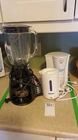 Photo of all three appliances on kitchen countertop: blender, coffee maker, kettle.