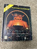 Front cover of the 1978 Advanced Dungeons and Dragons Player's Handbook showing fantasy illustration of demon and adventurers with title and author name Gary Gygax.