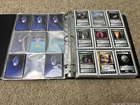 Open binder showing Star Trek playing cards in clear plastic sleeves. Cards have character images, symbols, and game text on them.