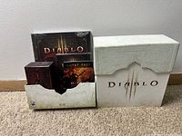 Diablo 3 Collector's Edition set components partially removed from main box on carpet.