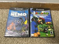 Front view of the two Nintendo GameCube game cases for Finding Nemo and Mario Golf Toadstool Tour, showing cover art.