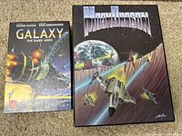 Top view of Galaxy The Dark Ages and Moon Dragon game boxes showing cover art with spaceships and outer space themes.