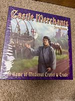 Front of sealed Castle Merchants board game box showing medieval merchant and horse with castle background