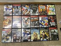 Photo showing 18 PlayStation 2 game cases arranged in 3 rows of 6 showing cover art and titles.