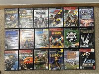 Photo of 20 used PlayStation 2 games in cases arranged in a grid on a wooden surface.