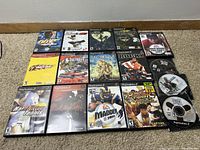 Photo showing full layout of 13 PlayStation 2 game cases and discs including titles 007 Nightfire, Crazy Taxi, Final Fantasy XII, Devil May Cry 3, Madden 2003, Rocky, Tiger Woods 2004, Street Fighter, Guitar Hero, and more.