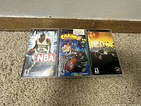 Three PSP game cases lined up showing front covers for NBA, Crash Tag Team Racing, and Need For Speed Undercover