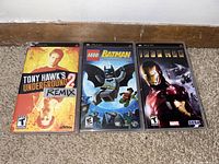 Three PSP game cases showing front covers: Tony Hawk's Underground 2 Remix, LEGO Batman, Ironman