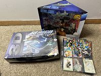 Star Trek figurine box on the top right, 3D gaming glasses box bottom left, and various cards on the right side in the photo.