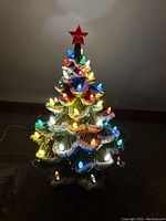 Tree illuminated showing multi-colored bulbs and red star topper