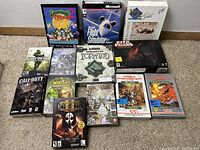 Full view of 14 vintage PC game big box covers arranged on carpet, showing diverse titles.