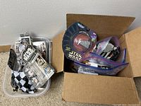 Open cardboard box and plastic tub containing Star Wars toys, mainly figures on cards and some loose figures.